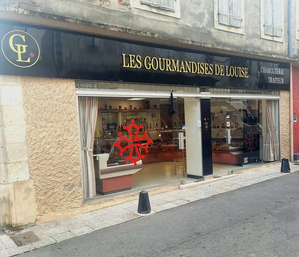 Enseigne noire à lettrage doré Les Gourmandises de Louise sur une devanture de commerce